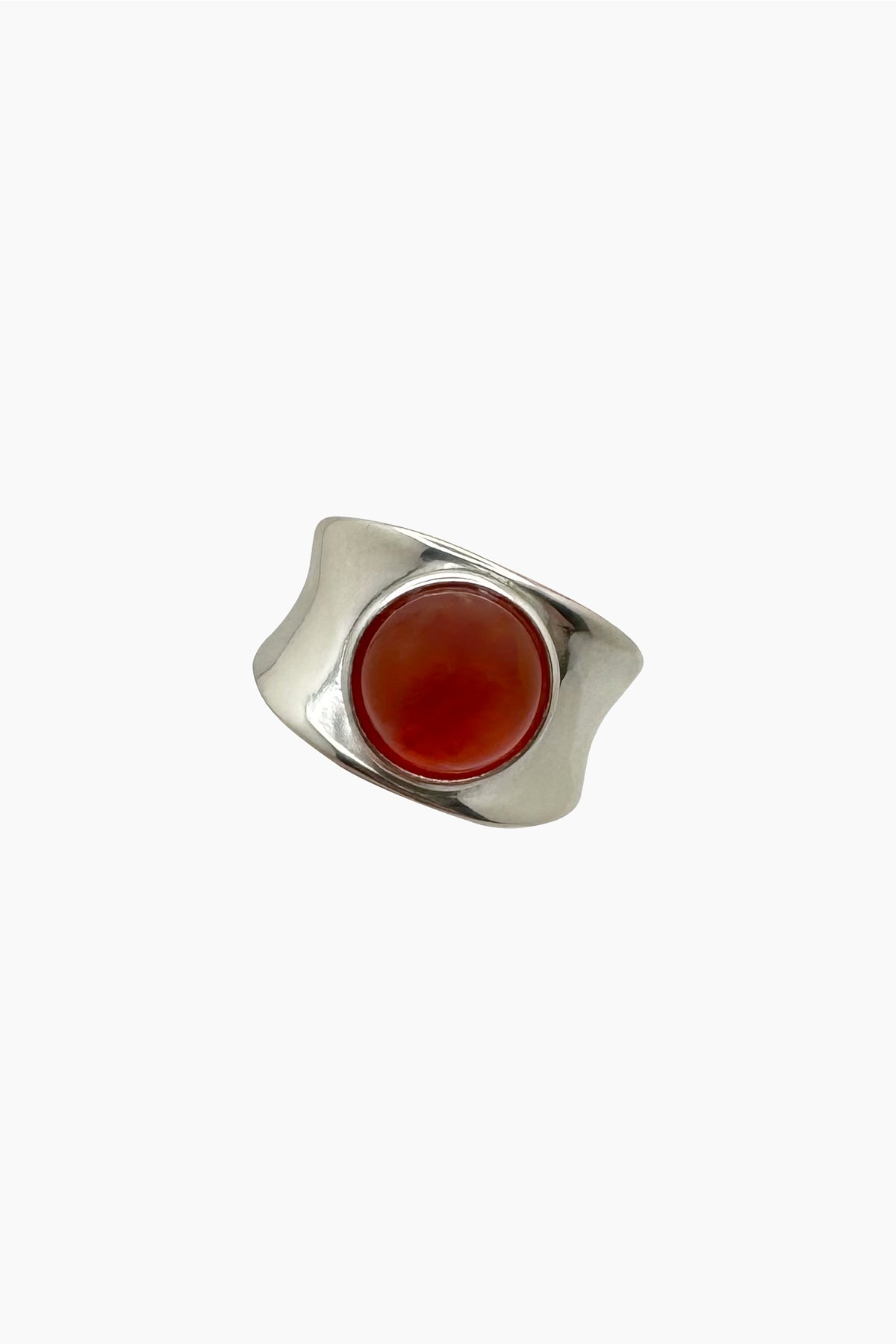 Alexandra Ring in chunky sterling silver with a smooth carnelian cabochon, shown in a flat lay against a neutral background.