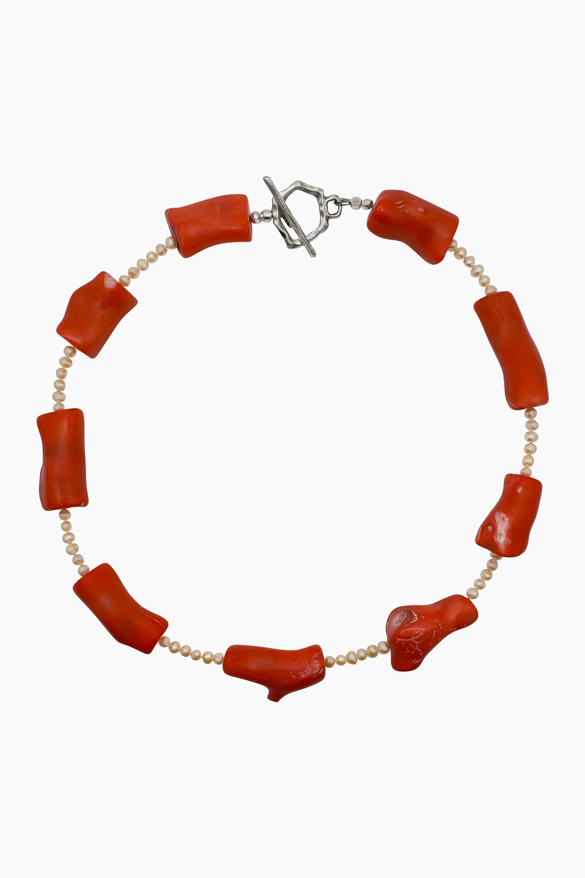 Product shot of the Coral Necklace, featuring chunky coral beads and freshwater pearls. A statement piece inspired by the ocean, combining bold coral with elegant pearls.