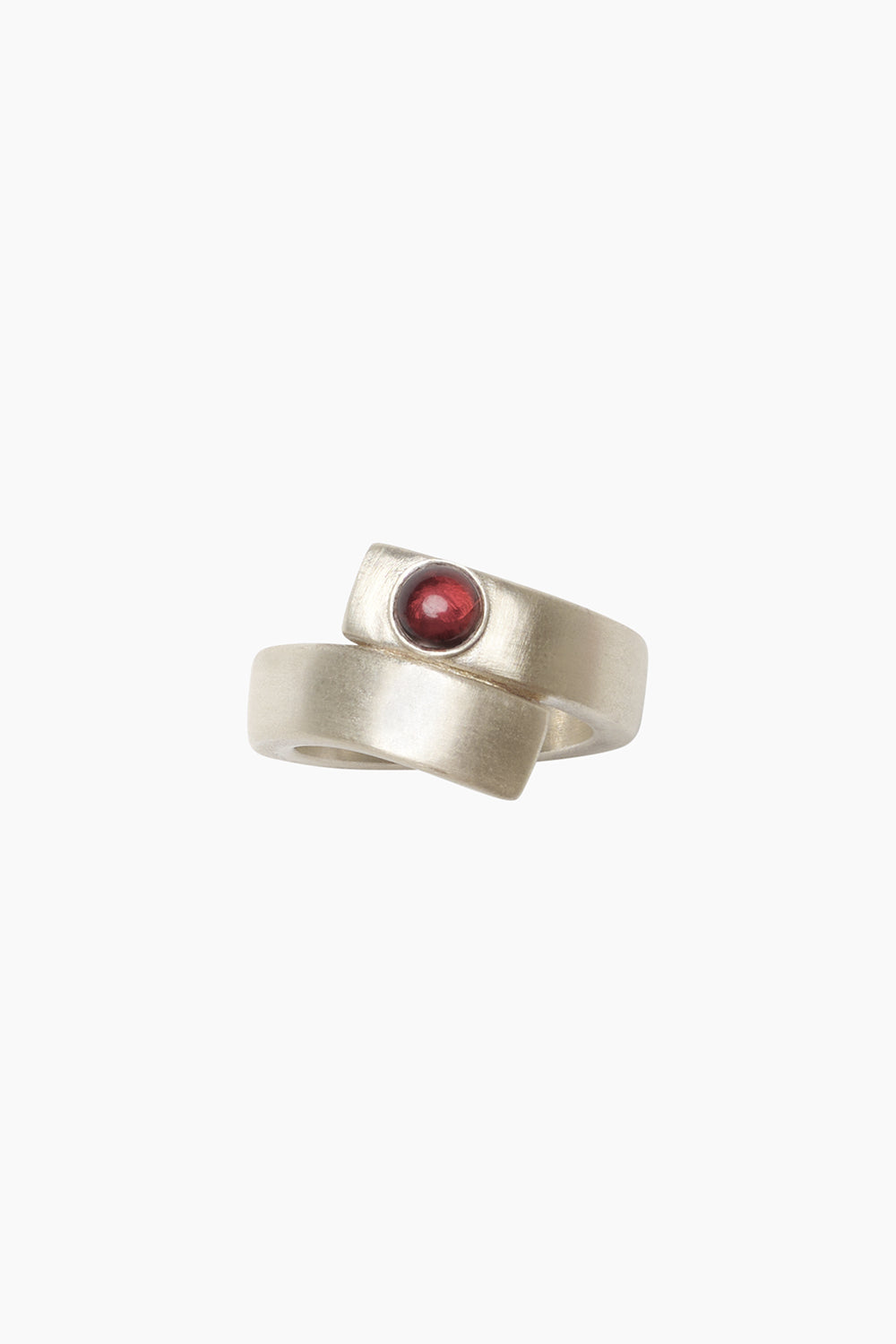 The Fervor Ring — sculptural bypass ring hand-cast in sterling silver with round garnet stone, product view on white background.