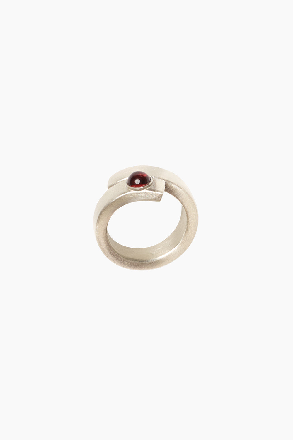 The Fervor Ring — side profile of sterling silver bypass ring with sculptural curves, set with deep red garnet stone.