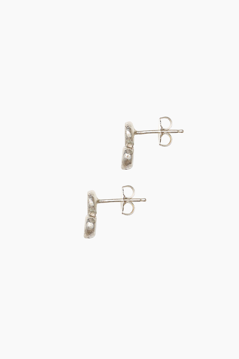 Side profile of the Mirage Earrings — sculptural pebble studs in sterling silver.