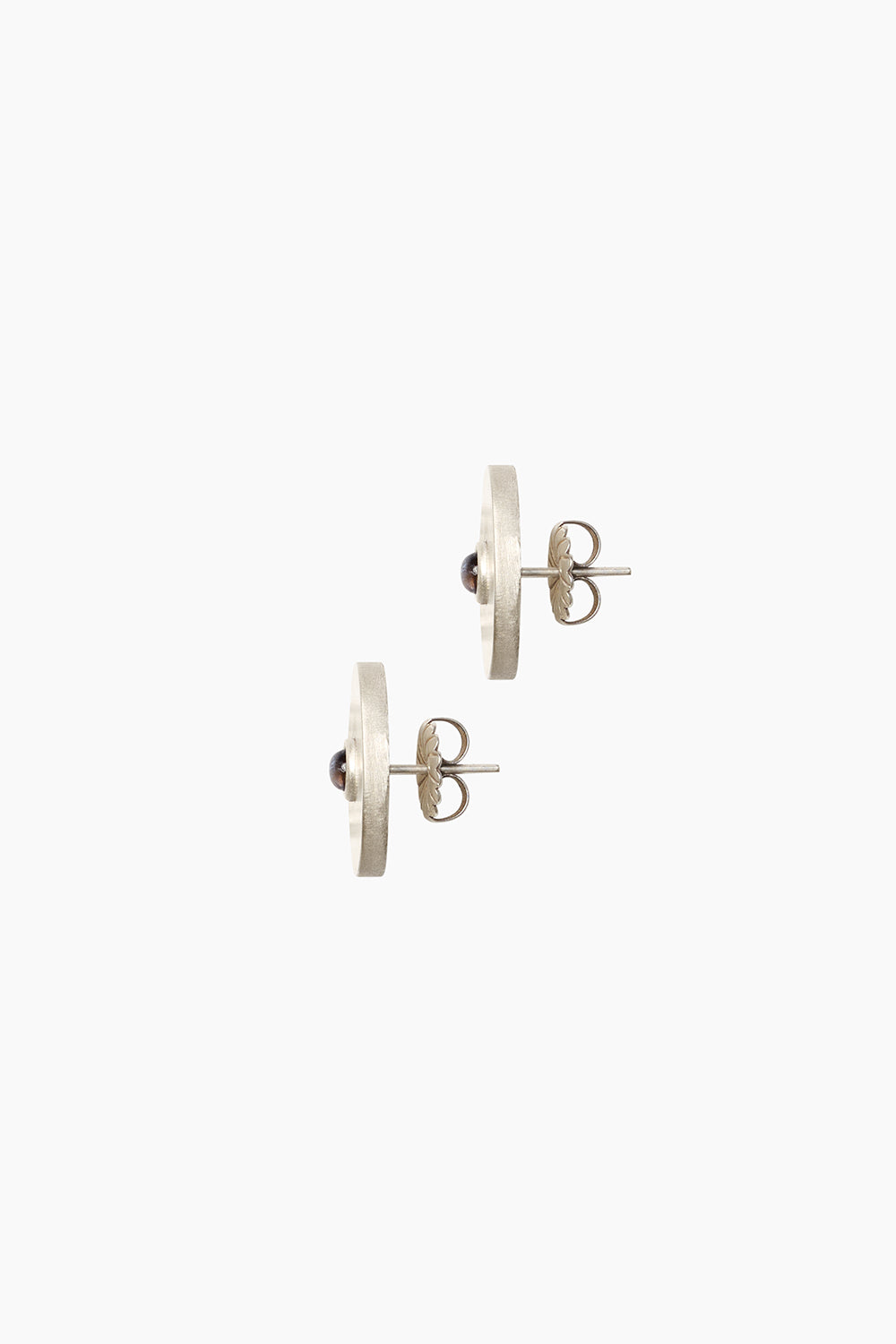 Side profile of the Oracle Earrings — thick sterling silver medallion stud with iolite stone, showing depth and sculptural form.