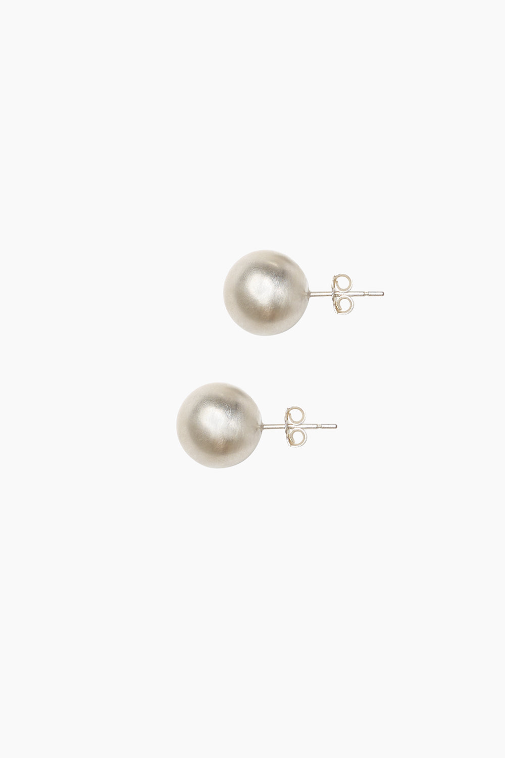 Close-up side view of the Orb Earrings, sterling silver oversized stud earrings with a polished spherical shape.