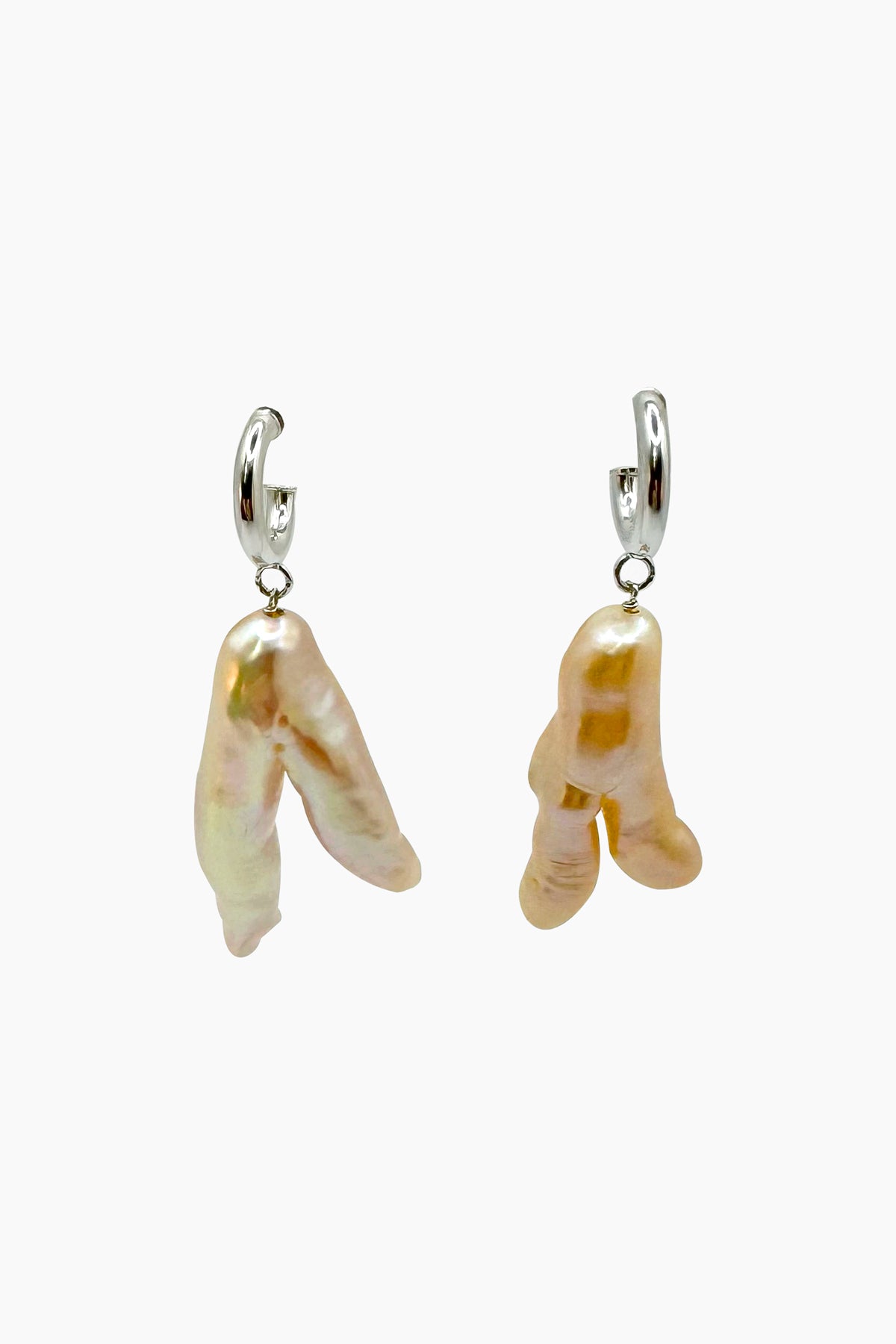 Close-up of the Peggy earrings—irregular freshwater pearls suspended from sterling silver half hoops. Each pearl is uniquely shaped, nicknamed 'chicken’s feet' for its organic, natural form