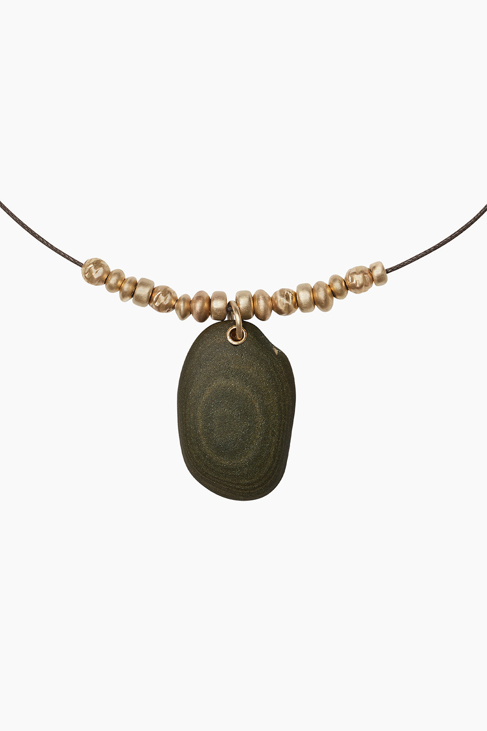Talis Necklace close-up — spiral pebble pendant paired with 14k gold-filled saucer beads on a brown waxed cotton cord.