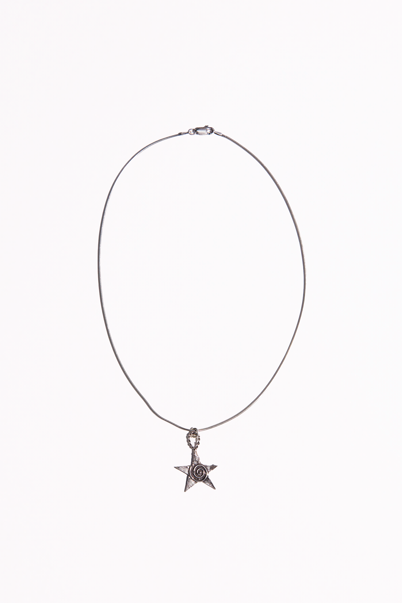 A Sterling Silver necklace featuring a hand cast star pendant with a spiral on it.