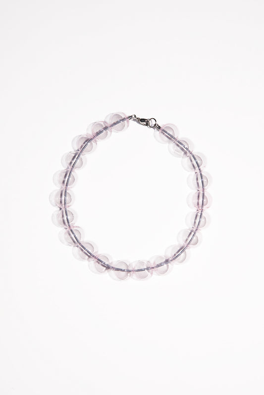 Clear pink beaded necklace. Each bead is hand blown glass and strung on a grey leather cord.