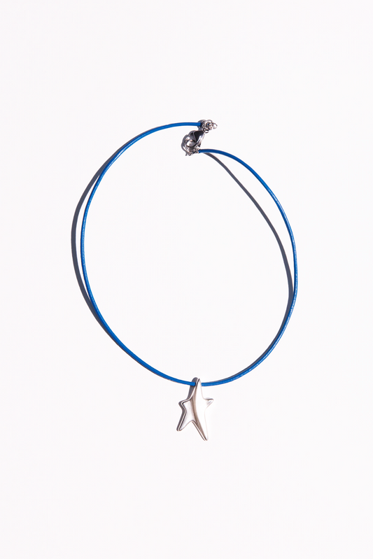 The Liv necklace features a hand cast star pendant strung on a blue leather cord.