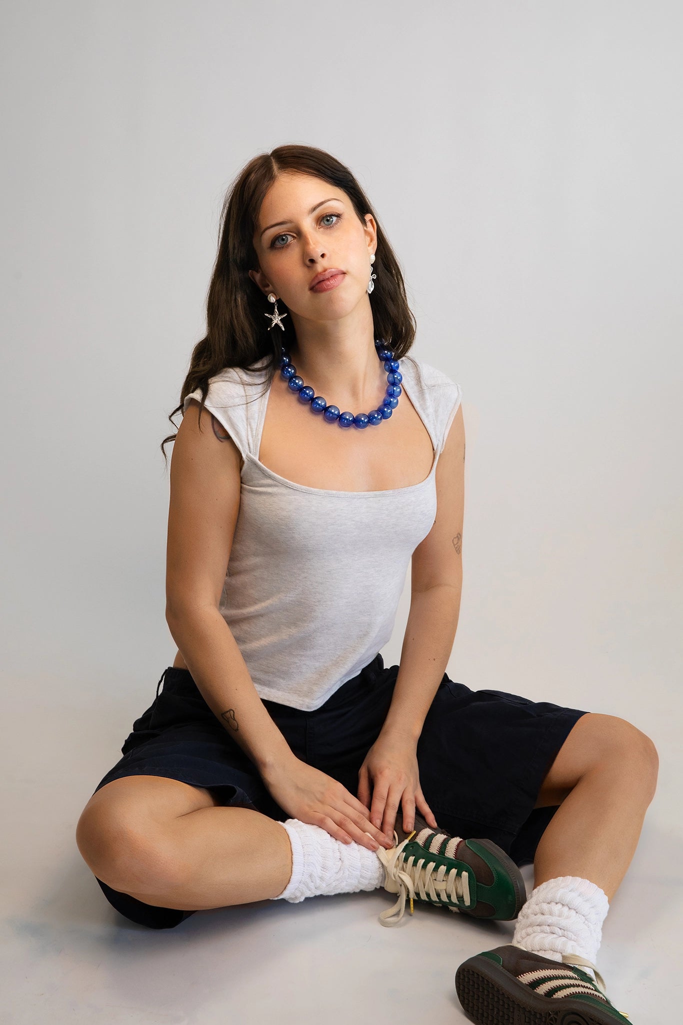 A model wearing a clear cobalt blue beaded necklace. Each bead is hand blown glass and strung on a blue leather cord.