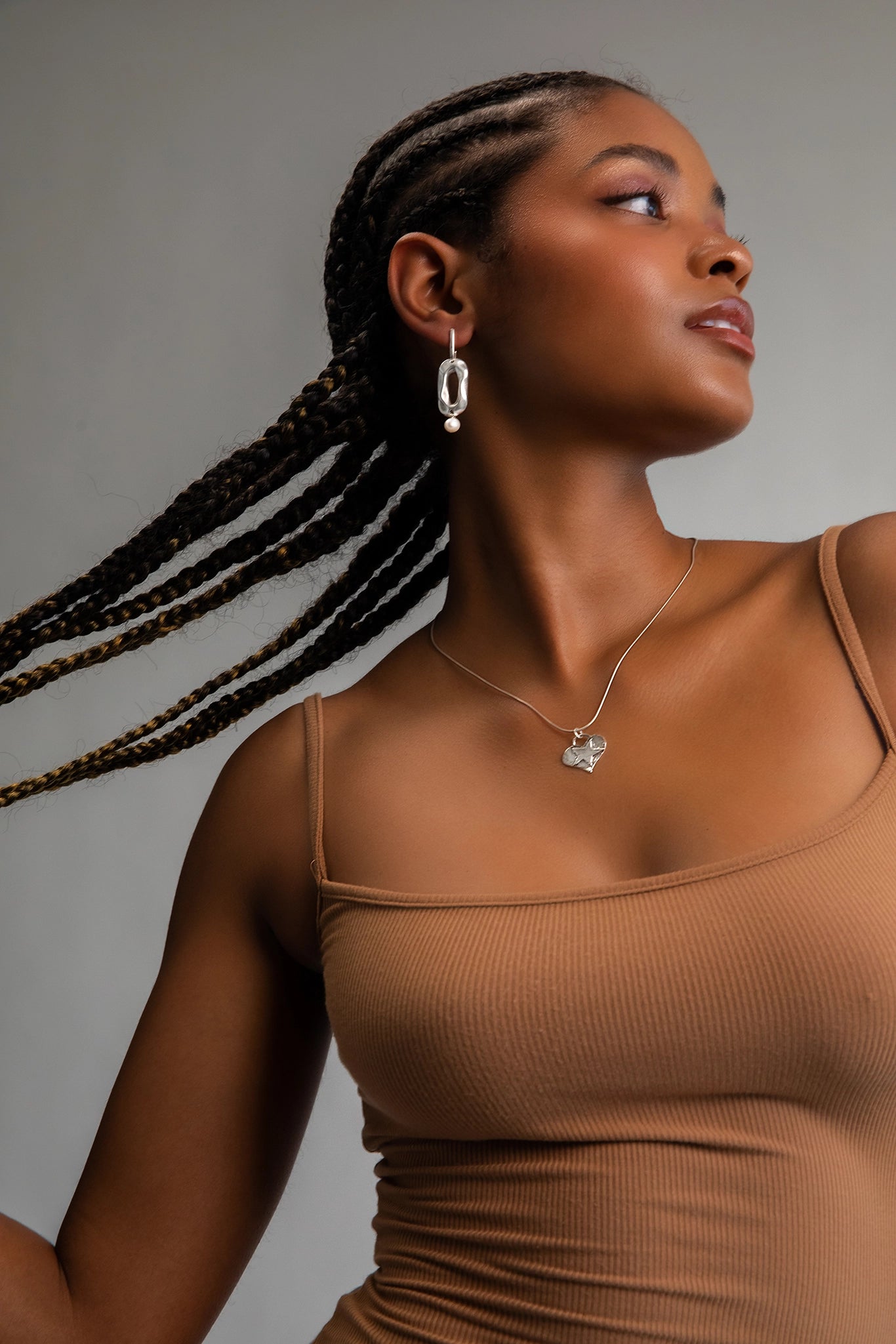 Model wearing solid .925 Sterling Silver earrings that feature geometric shapes hand cast in Sterling Silver plating, adorned with AAA-quality freshwater pearls for a touch of sophistication.