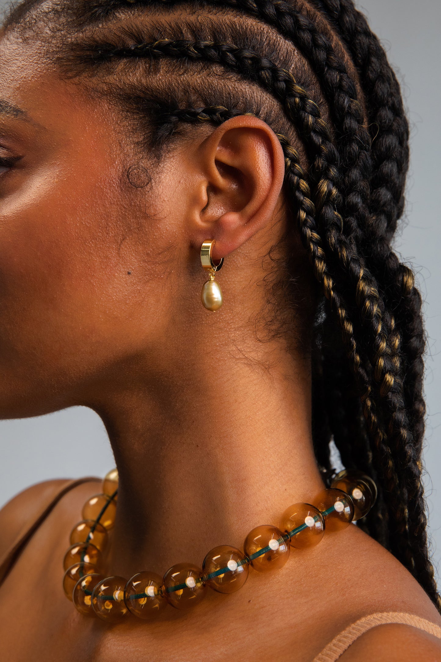 Model wearing green freshwater baroque pearl drops on 18K Gold Plated hoops.