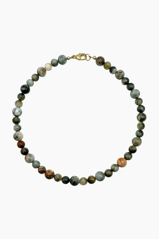 Product photo of the Santal Necklace, featuring alternating large and small eagle eye quartz beads in moody, earthy tones with a subtle reflective sheen. 