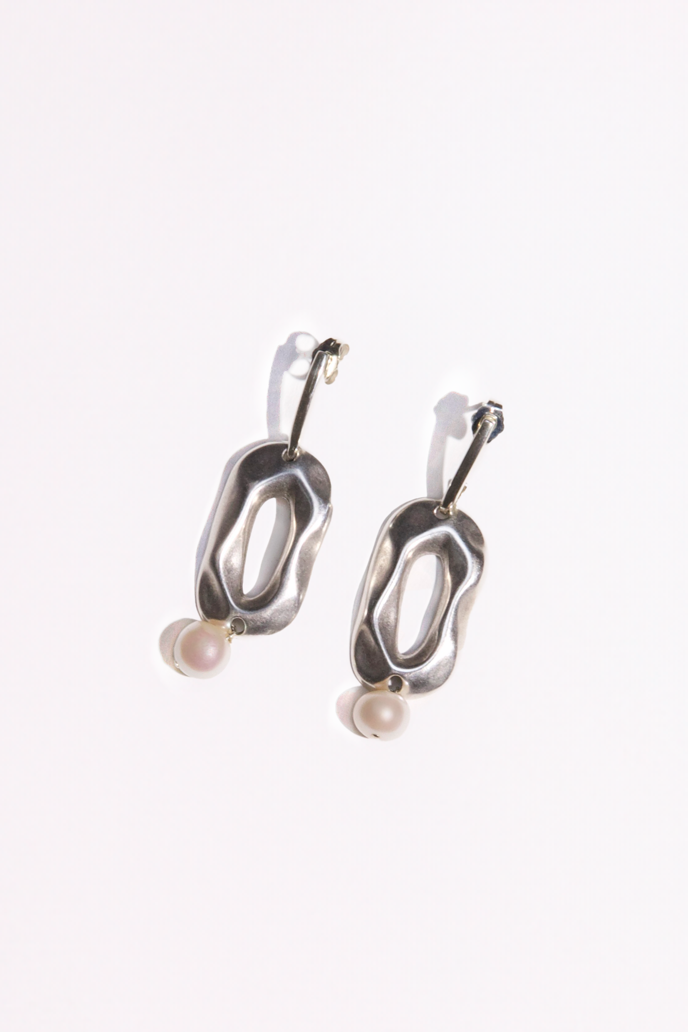 Introducing the Sloane Earrings, crafted from solid .925 Sterling Silver. These elegant earrings feature geometric shapes hand cast in Sterling Silver plating, adorned with AAA-quality freshwater pearls for a touch of sophistication.  