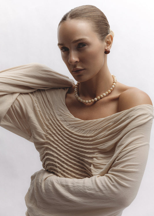 The Dawn Necklace in mother of pearl beads worn around the neck