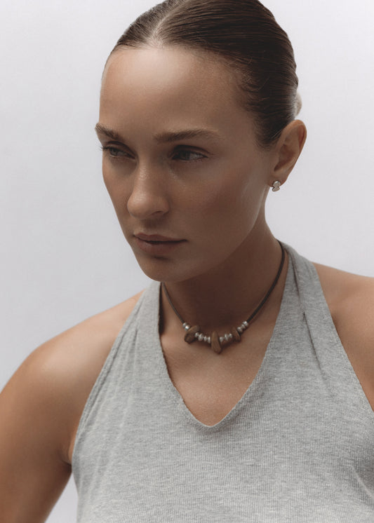 Ruins Necklace — stone and sterling silver beads strung on a brown waxed cotton cord, photographed on a white background.
